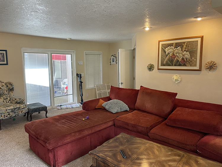 Red couch in living room with back screen door